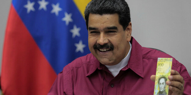 Venezuelas Präsident zeigt lachend einen Geldschein Venezuelas Präsident zeigt lachend einen Geldschein