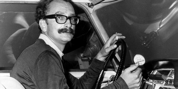 Schwarz/weiß Bild. Feltrinelli sitzt am Steuer eines Autos. Schwarz/weiß Bild. Feltrinelli sitzt am Steuer eines Autos.
