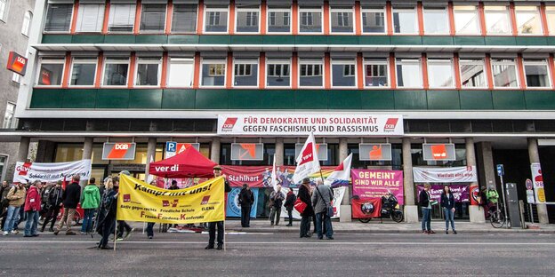 Menschen stehen mit Transparenten vor dem Münchner DGB-Gebäude Menschen stehen mit Transparenten vor dem Münchner DGB-Gebäude