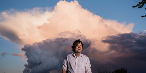 Künstler John Maus steht vor einer großen Wolke Künstler John Maus steht vor einer großen Wolke