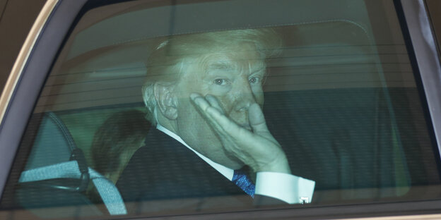 US-Präsident Trump sitzt in einem Auto und winkt US-Präsident Trump sitzt in einem Auto und winkt