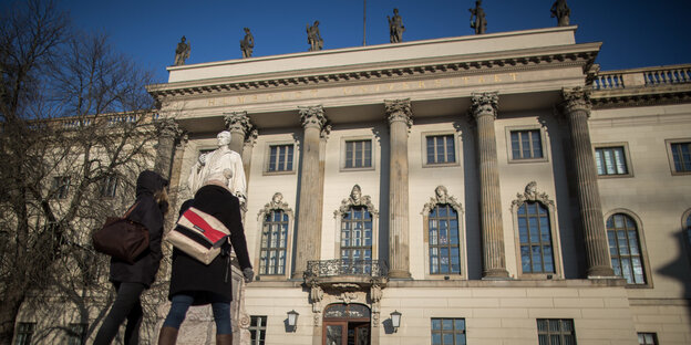 Das Hauptgebäude der Humboldt-Universität mit zwei Studentinnen davor