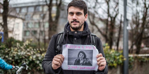 Kerem Schamberger hält ein Plakat in der Hand auf der die Freilassung einer in der Türkei inhaftierten Journalistin gefordert wird Kerem Schamberger hält ein Plakat in der Hand auf der die Freilassung einer in der Türkei inhaftierten Journalistin gefordert wird