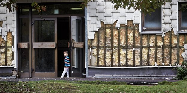 Ein Junge lehnt an in einer öffenen Tür