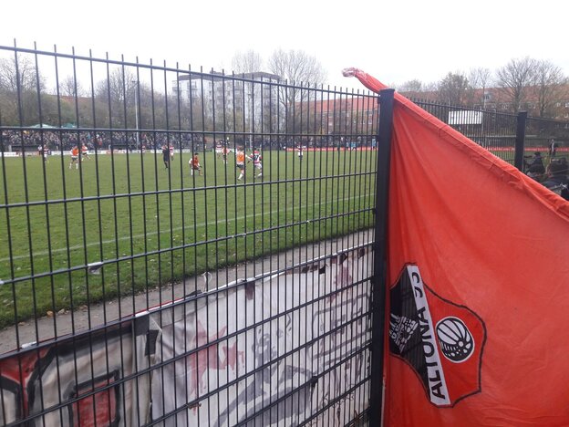 Eine Fan-Fahne von Altona 93 ist auf den Stahlzaun des Stadions gelehnt. Eine Fan-Fahne von Altona 93 ist auf den Stahlzaun des Stadions gelehnt.