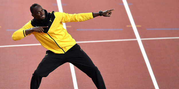 Läufer Usain Bolt steht auf einer Laufbahn Läufer Usain Bolt steht auf einer Laufbahn