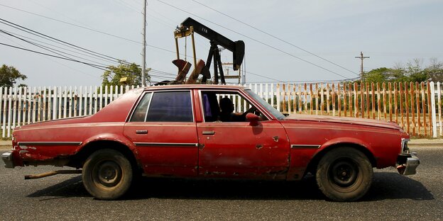 Ein Auto, dahinter eine Ölpumpe Ein Auto, dahinter eine Ölpumpe