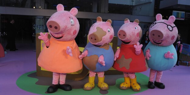 Menschen in Kostümen stellen Peppa Wutz und andere Charaktere aus der gleichnahmigen Kinderserie dar