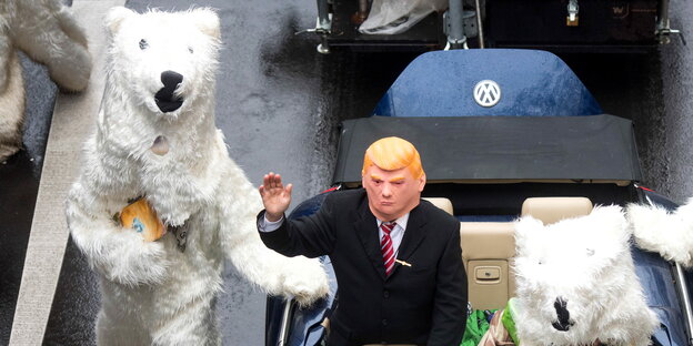 eine Trump-Puppe, daneben eine Mensch in einem Eisbärenkostüm eine Trump-Puppe, daneben eine Mensch in einem Eisbärenkostüm
