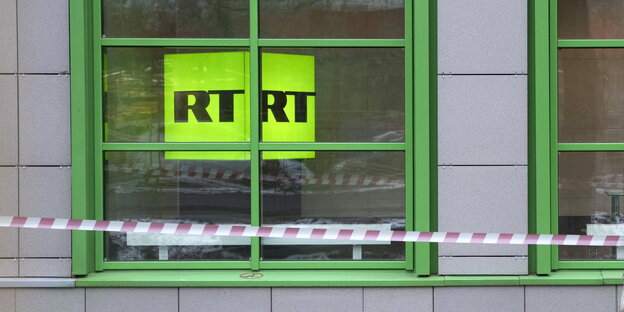ein Fenster, hinter dem man ein grünes Schild sieht, auf dem „RTRT“ steht ein Fenster, hinter dem man ein grünes Schild sieht, auf dem „RTRT“ steht