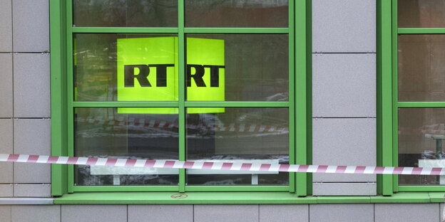 ein Fenster, hinter dem man ein grünes Schild sieht, auf dem „RTRT“ steht