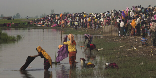 Menschen waschen ihre Kleidung im Fluss Menschen waschen ihre Kleidung im Fluss