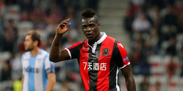 Mario Balotelli läuft über das Spielfeld und hebt einen Arm Mario Balotelli läuft über das Spielfeld und hebt einen Arm