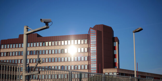 In der braun-beigen Fassade des Bundesamts für Verfassungsschutz in Köln spiegelt sich die Sonne, der Himmel dahinter ist strahlend blau