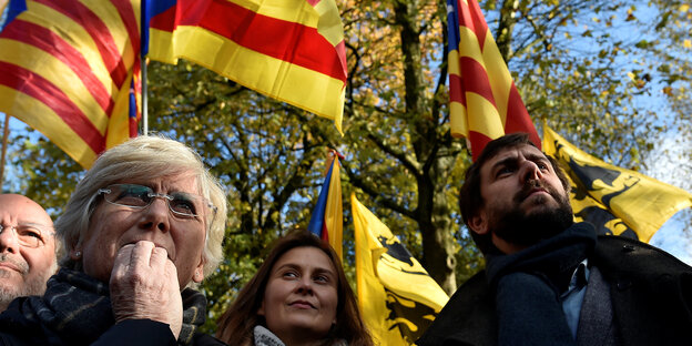 Menschen stehen zusammen und halten die Fahne Kataloniens Menschen stehen zusammen und halten die Fahne Kataloniens