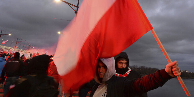 Menschen in einer Menschenmenge tragen eine Flagge Menschen in einer Menschenmenge tragen eine Flagge