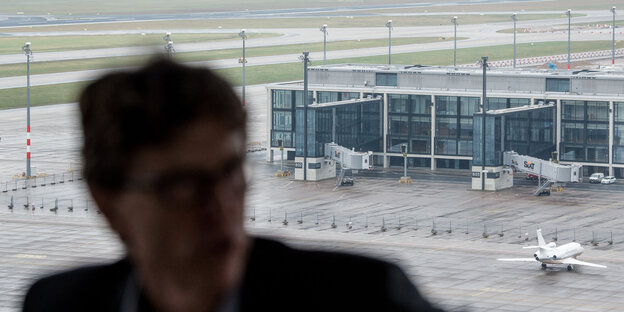 Die Silhouette eines Mannes vor einem Flughafen Die Silhouette eines Mannes vor einem Flughafen