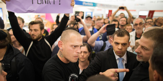 Ein linker Gegendemonstrant zeigt mit dem Finger auf Götz Kubitschek.