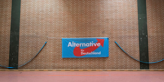 Das Logo der AfD hängt an einer braunen Wand Das Logo der AfD hängt an einer braunen Wand