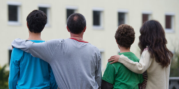 Vier Flüchtlinge sitzen auf einer Mauer. Vier Flüchtlinge sitzen auf einer Mauer.