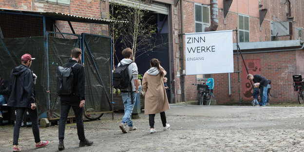 Junge Leute gehen auf den Eingang der Zinnwerke zu Junge Leute gehen auf den Eingang der Zinnwerke zu