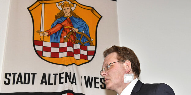 Ein Mann, Andreas Hollstein, unter dem Stadtwappen von Altena Ein Mann, Andreas Hollstein, unter dem Stadtwappen von Altena