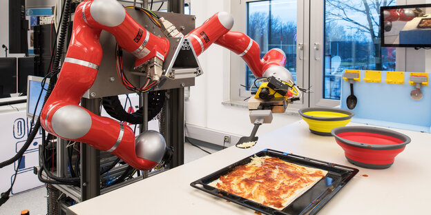 Ein Roboter belegt Pizza Ein Roboter belegt Pizza
