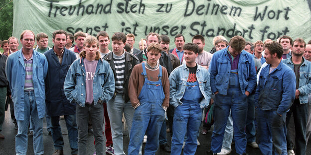Viele Arbeiter vor einem großen Transparent Viele Arbeiter vor einem großen Transparent