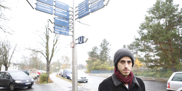 Junger Mann mit Mütze vor vielen Hinweisschildern Junger Mann mit Mütze vor vielen Hinweisschildern