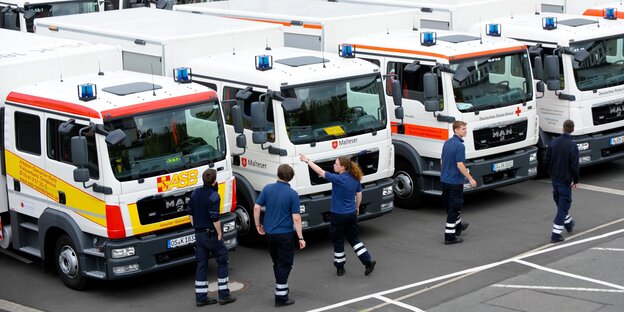 Sanitäter stehen vor Rettungsfahrzeugen Sanitäter stehen vor Rettungsfahrzeugen