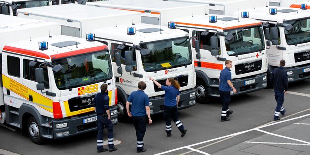 Sanitäter stehen vor Rettungsfahrzeugen