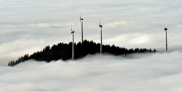 Vier Windkrafträder ragen aus einem Nebelmeer Vier Windkrafträder ragen aus einem Nebelmeer