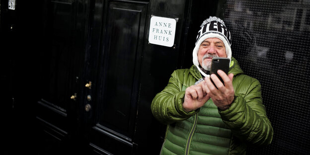 Ein Mann steht vorm Anne-Frank-Haus und macht ein Selfie Ein Mann steht vorm Anne-Frank-Haus und macht ein Selfie