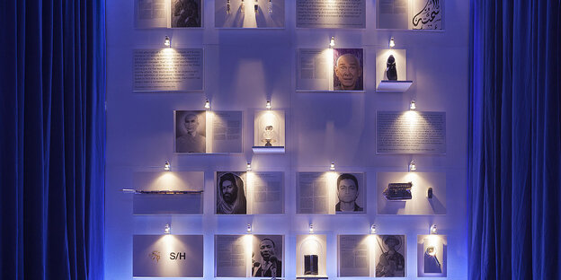 Fotos hängen an einer blau beleuchteten Wand Fotos hängen an einer blau beleuchteten Wand