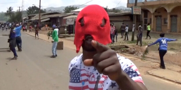 Ein mann mit roter Maske deutet auf die Kamera Ein mann mit roter Maske deutet auf die Kamera