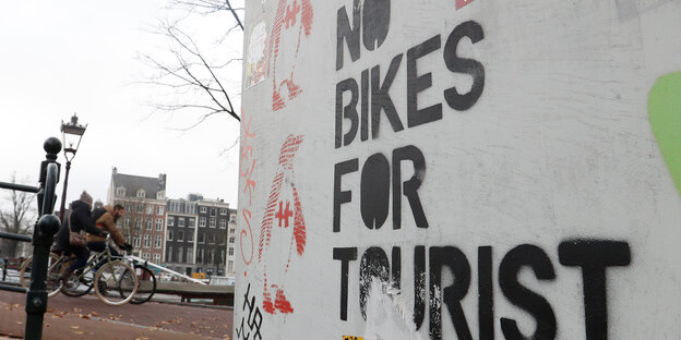 Aufschrift "No bikes for Tourists", dahinter ein Rad Aufschrift "No bikes for Tourists", dahinter ein Rad