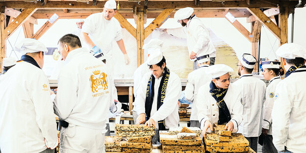 Mehrere BäckerInnen arbeitetn an einem Riesenchriststollen. Mehrere BäckerInnen arbeitetn an einem Riesenchriststollen.
