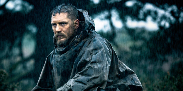 ein Mann mit Regencape in einem verregneten Wald ein Mann mit Regencape in einem verregneten Wald