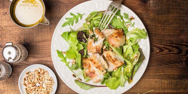 Ein Teller mit Salat, darauf Hähnchenstücke