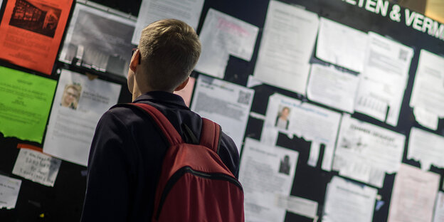 Ein Student guckt am Schwarzen brett nach Wohnungen Ein Student guckt am Schwarzen brett nach Wohnungen