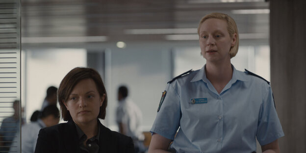 Zwei Frauen, eine klein, im Jackett, die andere groß, in Polizeiuniform Zwei Frauen, eine klein, im Jackett, die andere groß, in Polizeiuniform