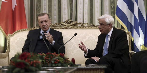 Der türkische Präsident Erdoğan sitzt beim Besuch in Athen mit Griechenlands Präsident Prokopis Pavlopoulos auf einem crèmefarbenen Sofa, Pavlopoulos spricht und gestikuliert Der türkische Präsident Erdoğan sitzt beim Besuch in Athen mit Griechenlands Präsident Prokopis Pavlopoulos auf einem crèmefarbenen Sofa, Pavlopoulos spricht und gestikuliert