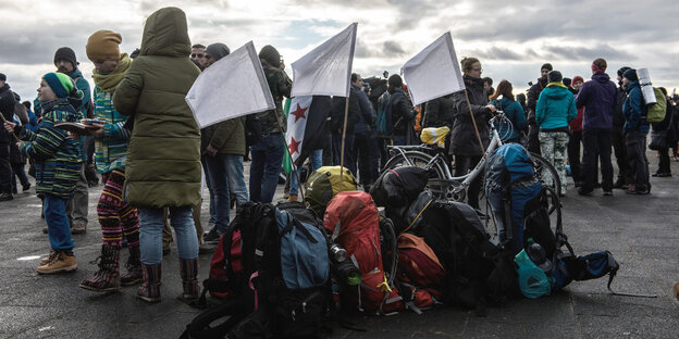 Weiße Fahnen wehen vor dem Start eines Solidaritäts-Marsches für Aleppo an Rücksäcken Weiße Fahnen wehen vor dem Start eines Solidaritäts-Marsches für Aleppo an Rücksäcken