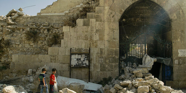 Zwei kleine Jungs mit Müllsäcken vor Trümmern in Aleppo Zwei kleine Jungs mit Müllsäcken vor Trümmern in Aleppo
