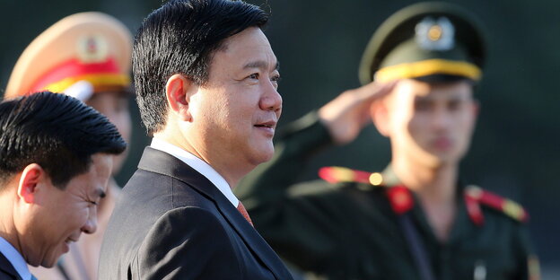 Dinh La Thang steht neben zwei Männern in Militäruniform Dinh La Thang steht neben zwei Männern in Militäruniform