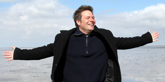 Robert Habeck streckt am Strand die Arme aus Robert Habeck streckt am Strand die Arme aus