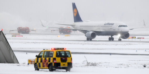 Ein Lufthansa-Flieger auf einem verschneiten Rollfeld Ein Lufthansa-Flieger auf einem verschneiten Rollfeld
