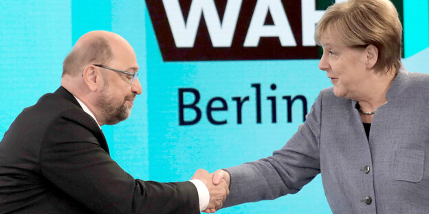Angela Merkel und Martin Schulz schütteln sich die Hände Angela Merkel und Martin Schulz schütteln sich die Hände