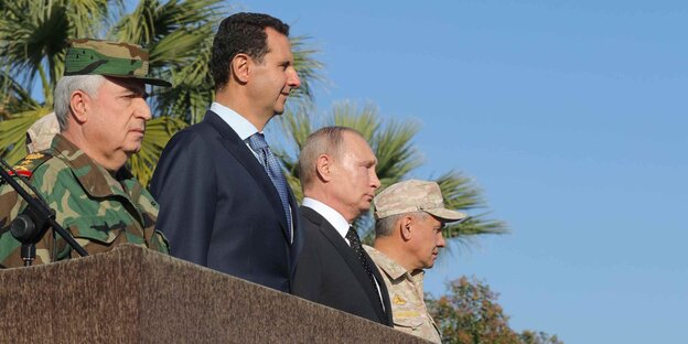 Assad und Putin auf einem Podium zwischen Generälen Assad und Putin auf einem Podium zwischen Generälen