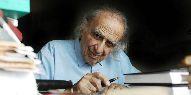 Giwi Margwelaschwili an einem Schreibtisch mit Bücherstapel Giwi Margwelaschwili an einem Schreibtisch mit Bücherstapel